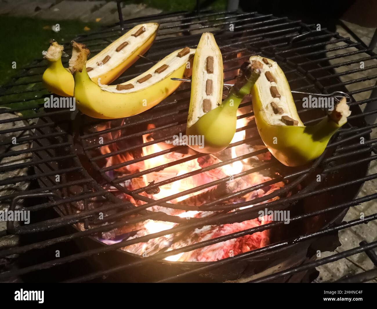 cucinare gustose banane con cioccolato sul fuoco in estate durante la lavorazione del bush Foto Stock