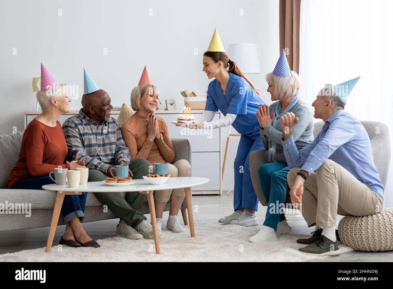 Gruppo di persone anziane che hanno festa di compleanno a casa di cura Foto Stock