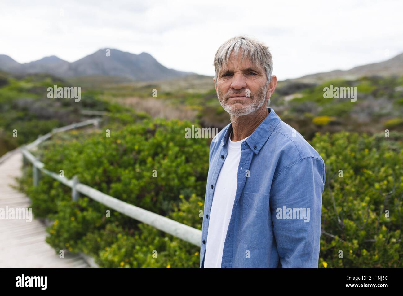 Ritratto di uomo maturo caucasico in piedi sul lungomare durante il fine settimana. Stile di vita, fine settimana e natura concetto. Foto Stock