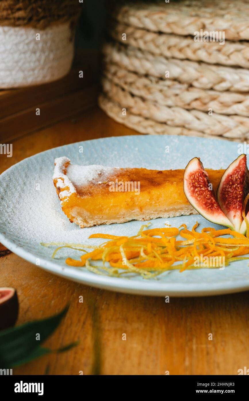 Un primo piano verticale del pezzo di crostata di cheesecake arancione con fig. Foto Stock