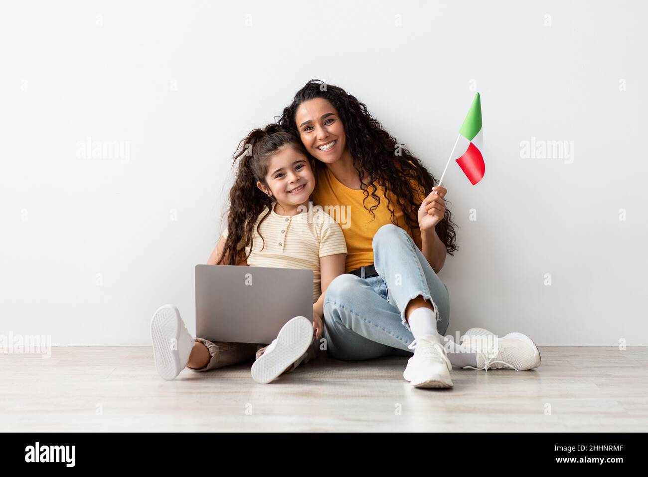 Ritratto di madre araba e bambina con laptop e bandiera italiana Foto Stock