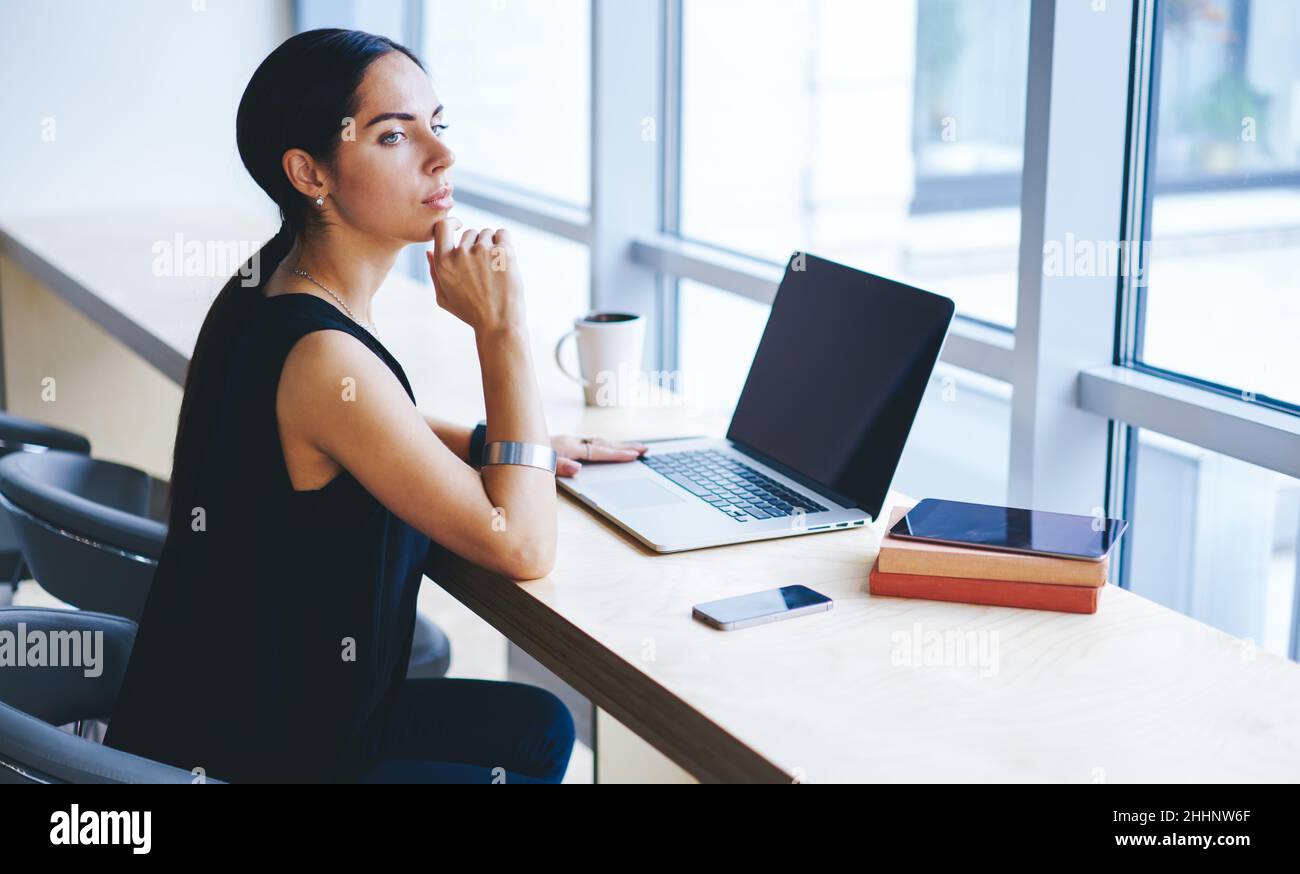 Lavoratore remoto pensivo seduto in un ambiente di lavoro moderno Foto Stock