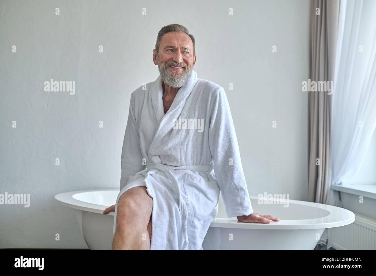 Un uomo felice e maturo sognando in bagno Foto Stock