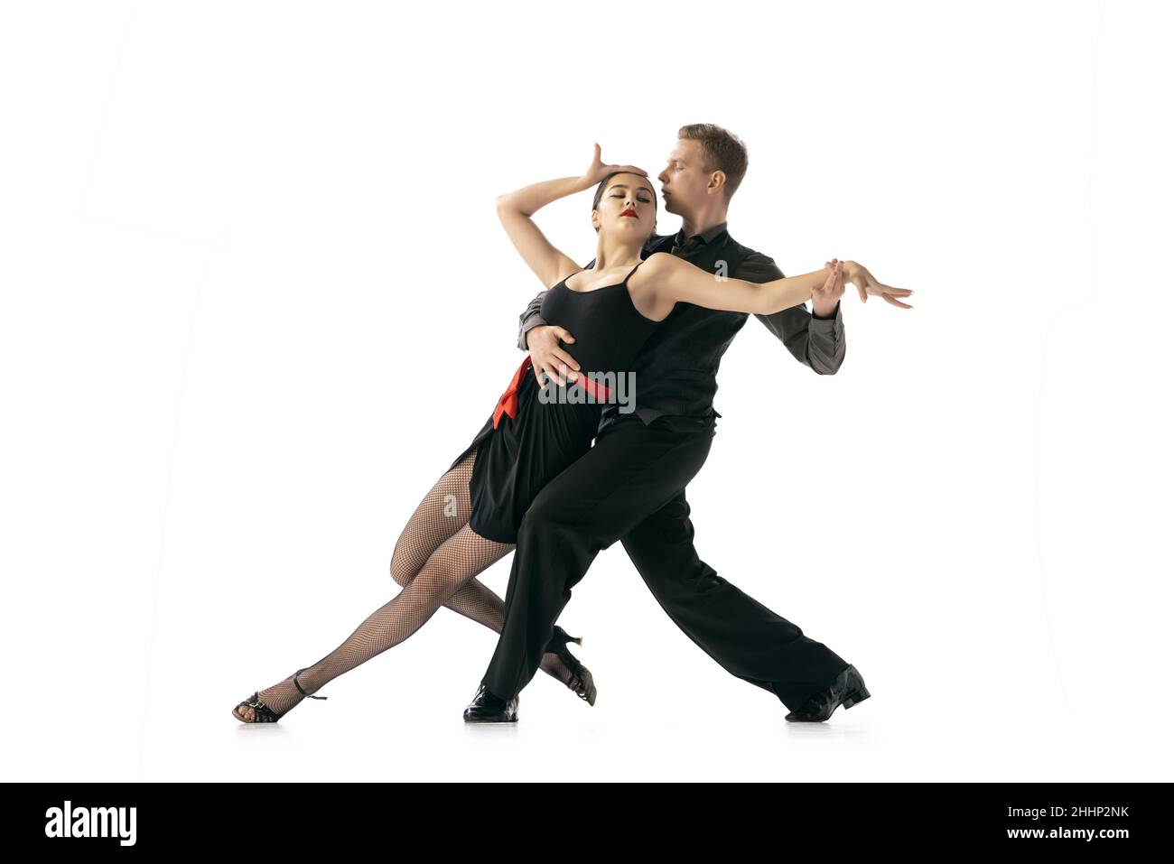 Flessibile giovane coppia danza tango argentino isolato su sfondo bianco studio. Artisti in costumi da palcoscenico nero Foto Stock