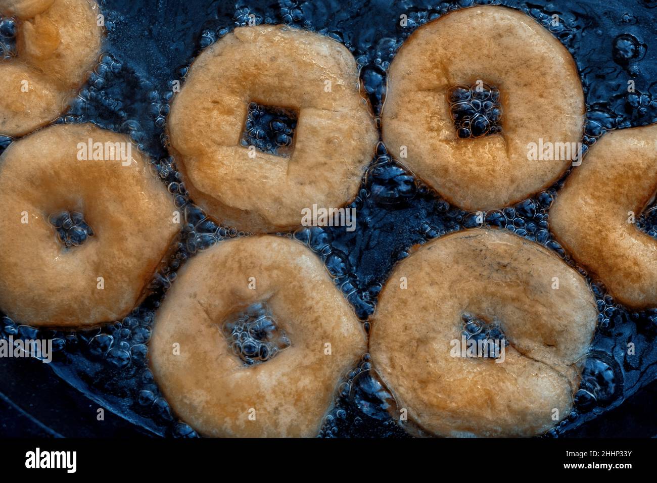 Ciambelle fatte in casa friggere in padella in ghisa all'aperto. Foto Stock