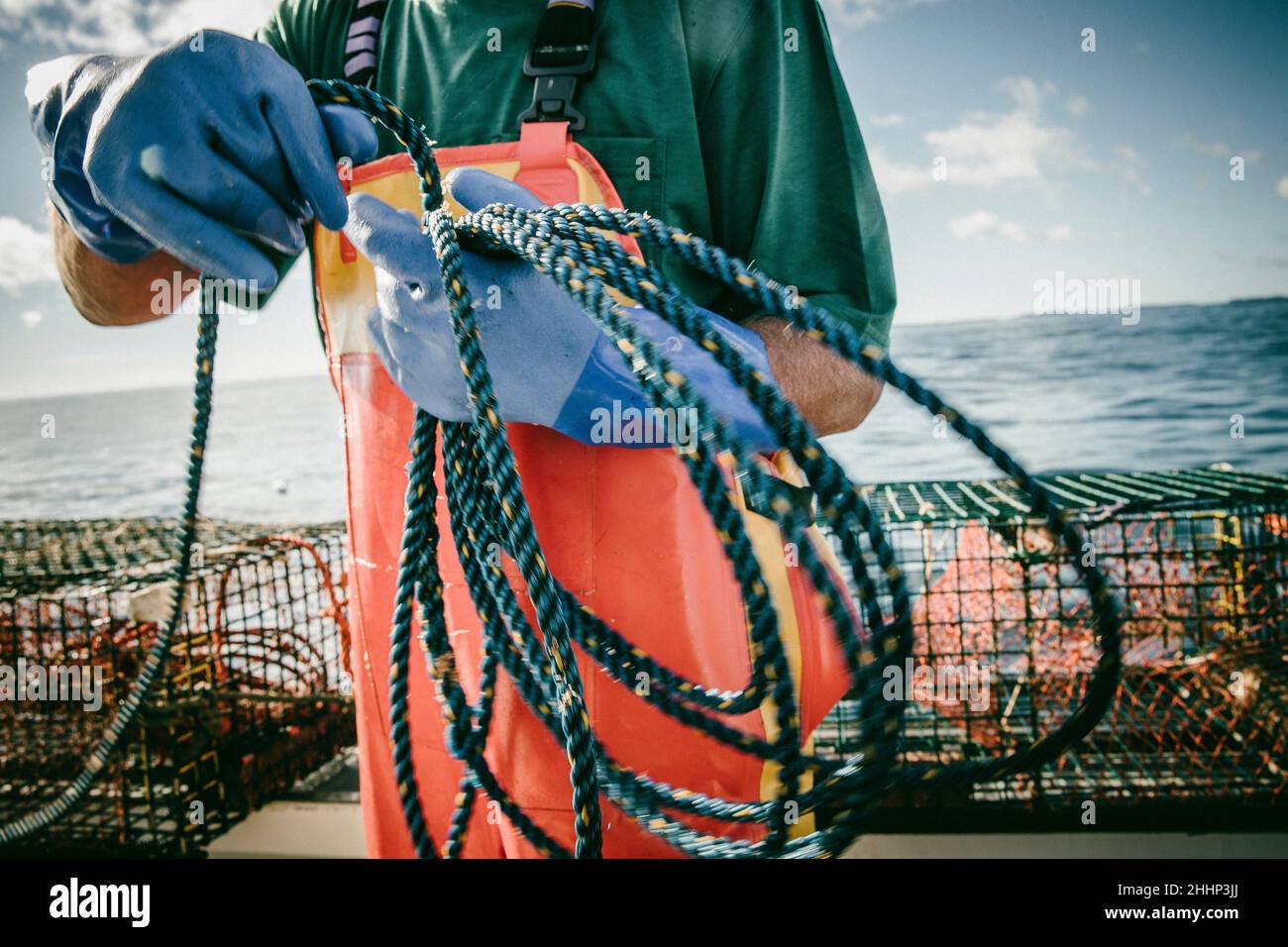Pescatore di aragosta che trasporta la corda sulla barca da pesca Foto Stock