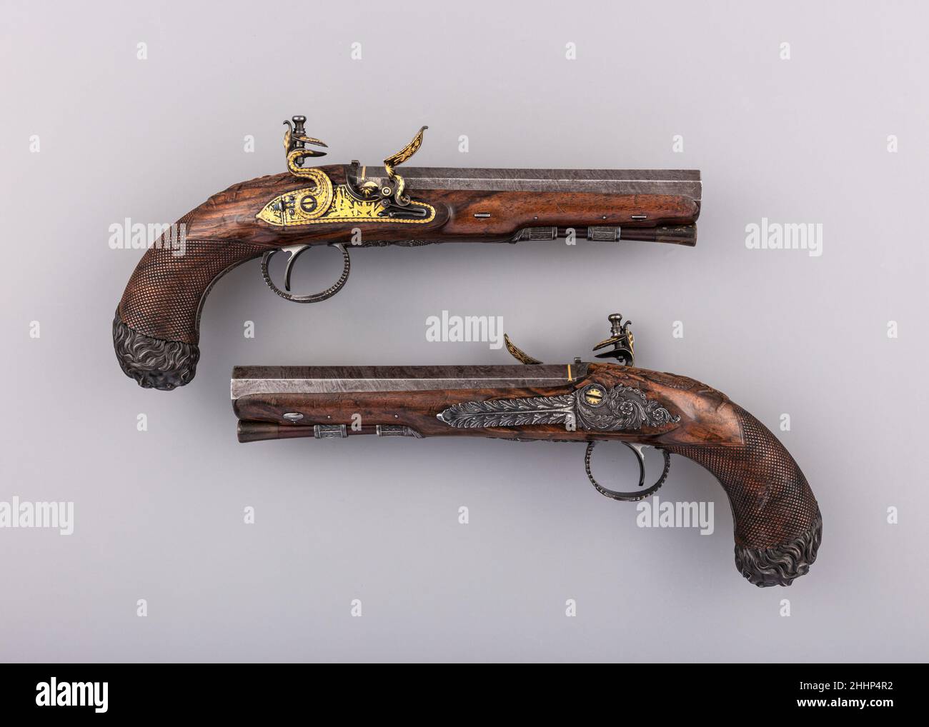 Coppia di pistole Flintlock 1815–34 John Manton & Son l'originale proprietario di questa coppia decorata in modo notevole rimane sconosciuto, ma l'opulenza delle pistole e il carattere continentale suggerisce che potrebbero appartenere a George IV (1762–1830) o a qualcuno nel suo cerchio. Le loro serrature intarsiate in oro sono le più sontuose mai prodotte dalla ditta John Manton durante la sua vita. L'aquila scolpita sul grip, una caratteristica che si trova anche su un paio di pistole del re, realizzate per lui quando era Principe di Galles, ora nella Collezione reale al Castello di Windsor (ACC. n. RCIN 6166), è qui ulteriormente arricchito con occhi intarsiati in oro. Si Foto Stock