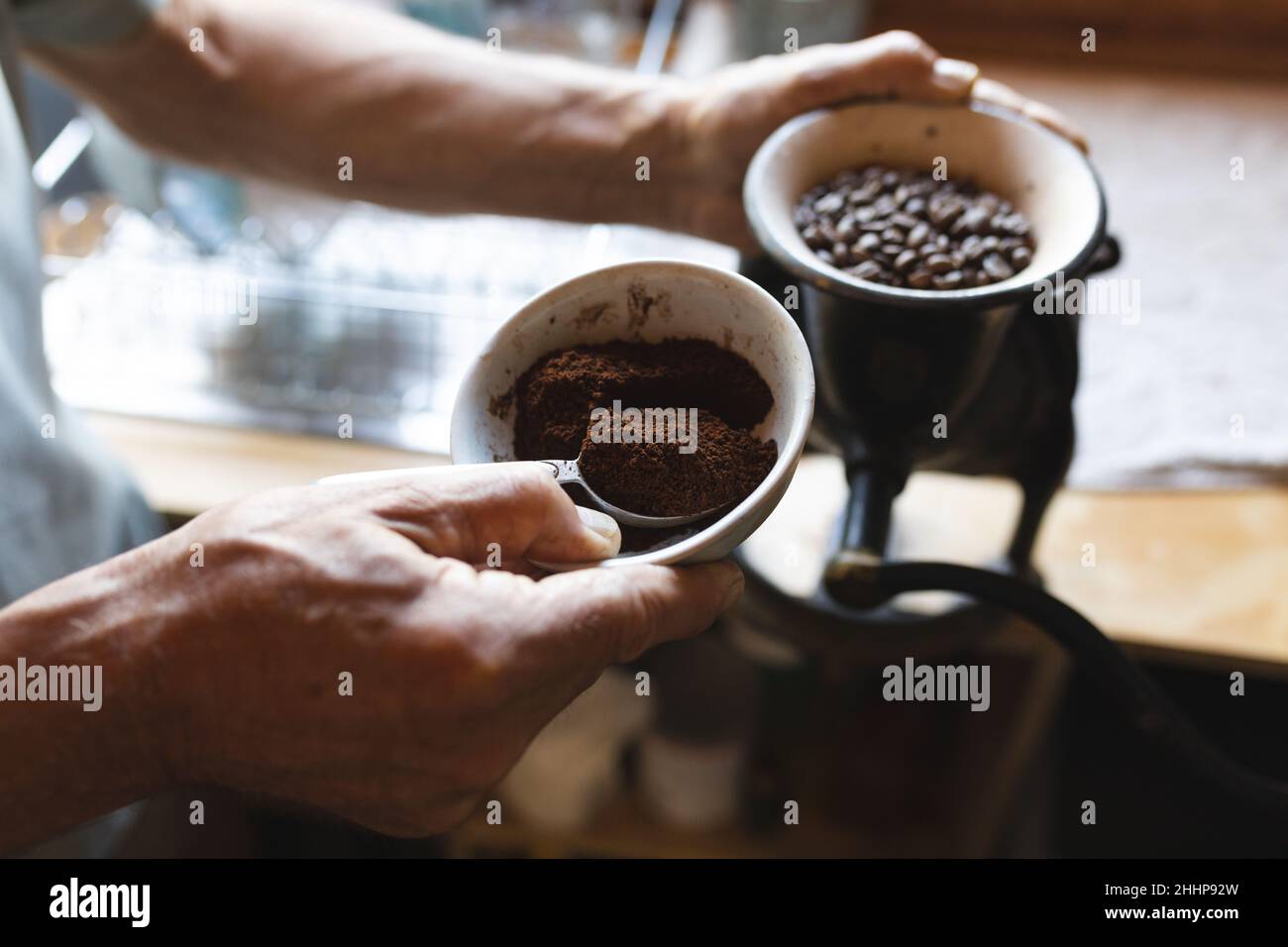 Metà sezione di uomo maturo caucasico preparazione caffè in cucina a casa di pannocini. Semplice vivere, stile di vita, bere e rinfresco. Foto Stock