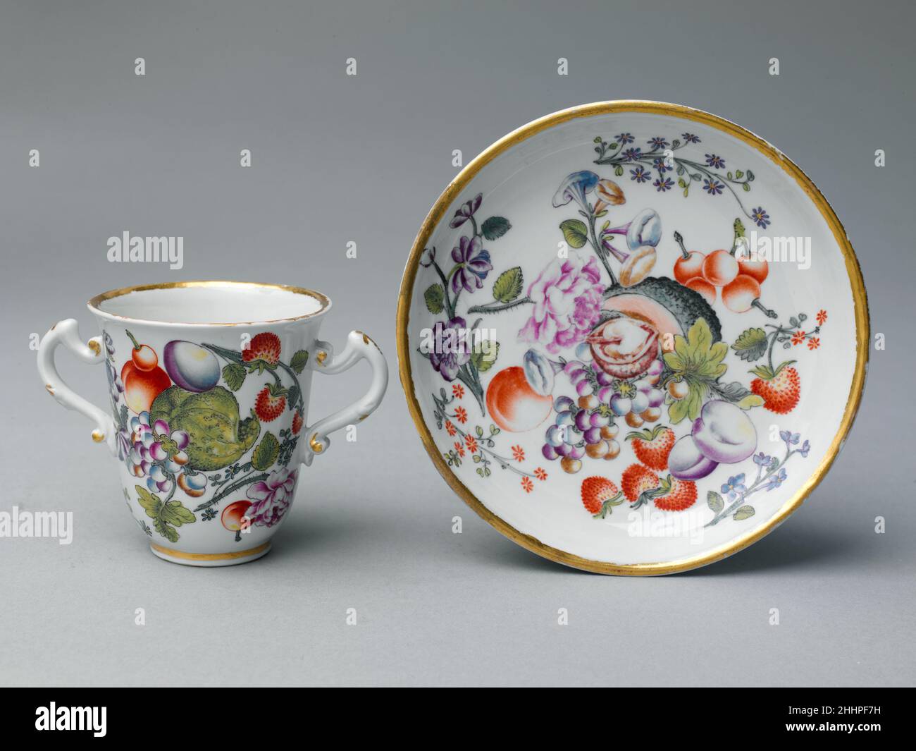 Bicchiere di cioccolato e piattino ca. 1735 la pittura di fiori Naturalistici di Vienna è stata eccezionale a Du Paquier a causa dell'uso attento delle tecniche differenti per distinguere le strutture dei fiori, dei frutti, delle zucche, dei rettili e dei piccoli mammiferi. Frutti come le pesche e le uve venivano spesso dipinte con punti di colore, nello stile miniaturista che era una specialità della manifattura; la buccia di meloni e zucche era impreziosita da sottili linee in inchiostro nero. Bicchiere di cioccolato e piattino. Austria, Vienna. CA. 1735. Porcellana a pasta dura. Ceramica-porcellana Foto Stock