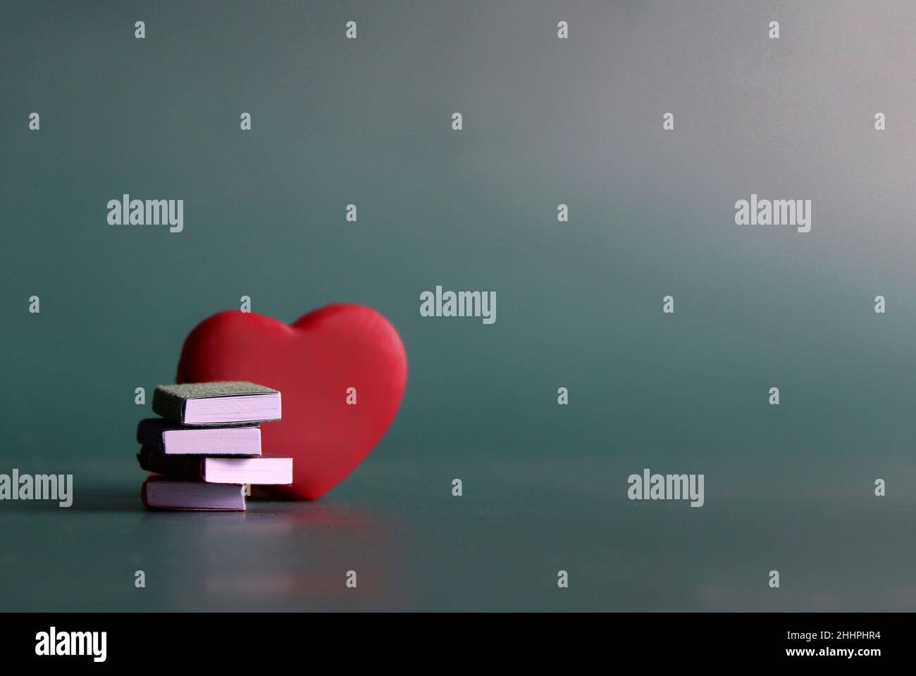 Bibliophile, concetto di amante del libro. Pila di libri e cuore rosso con spazio di copia per il testo Foto Stock