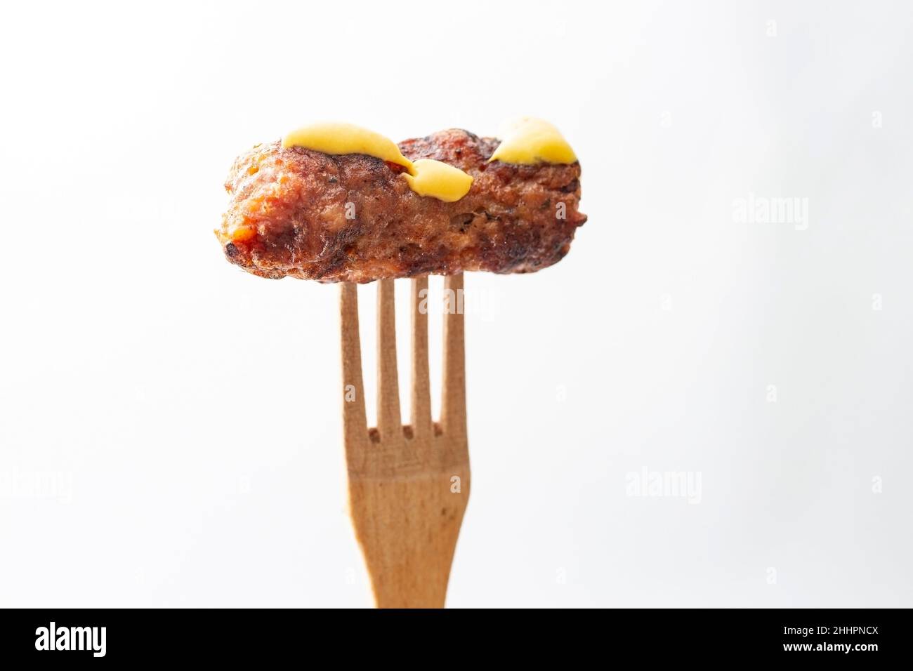 Carne tritata alla griglia tradizionale rumena, mici o mititei su forchetta di legno Foto Stock