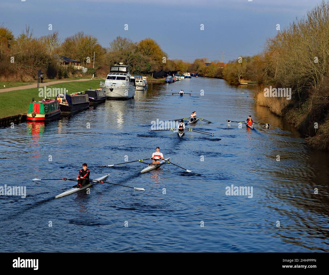 In una mattinata invernale luminosa, fresca e frizzante, una flotta di 6 canoe passa accanto alle barche del canale ormeggiate sul Gloucester e sul canale Sharpness al Ponte Sellars Foto Stock