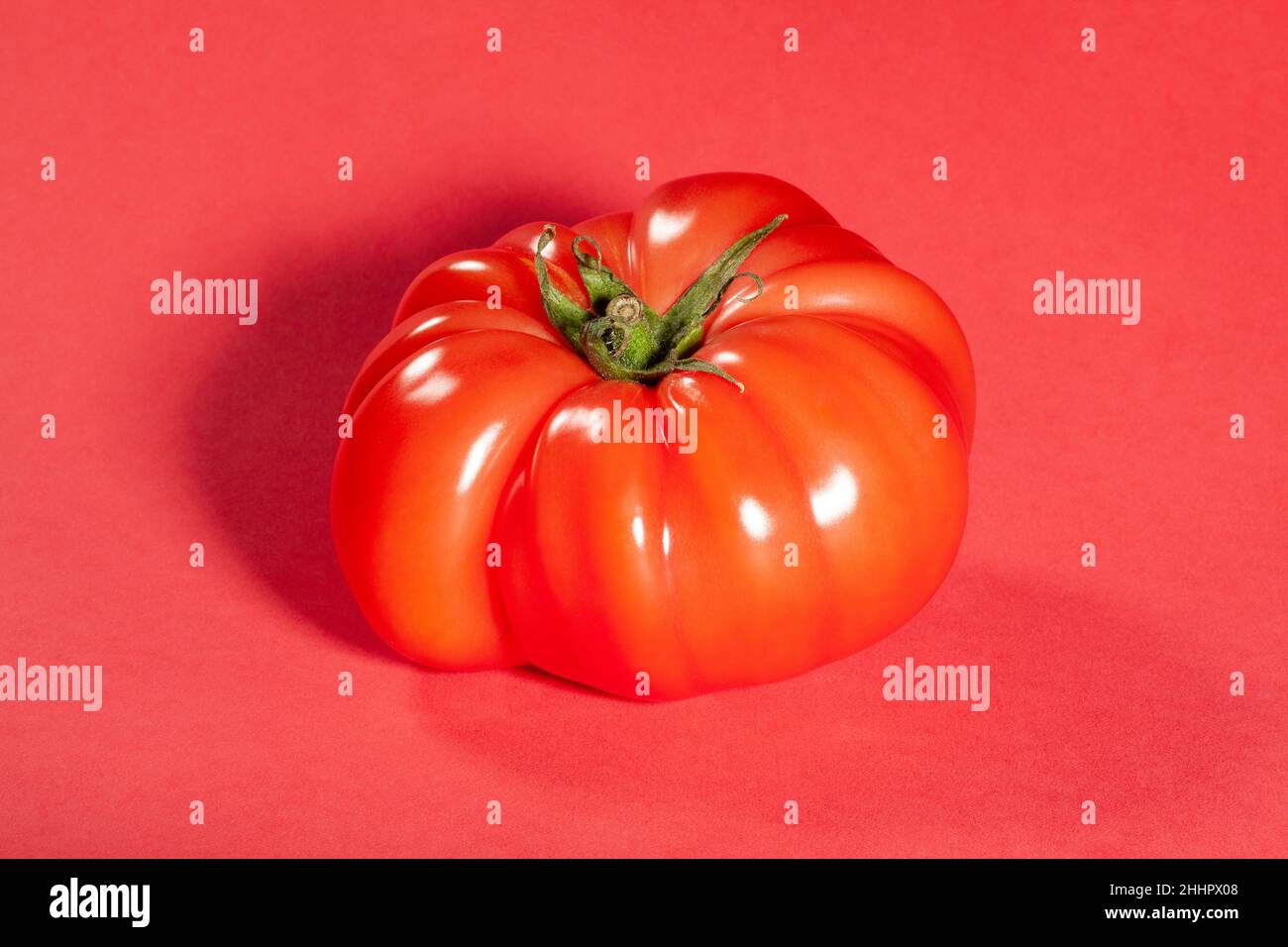 pomodoro rosa su sfondo rosso Foto Stock