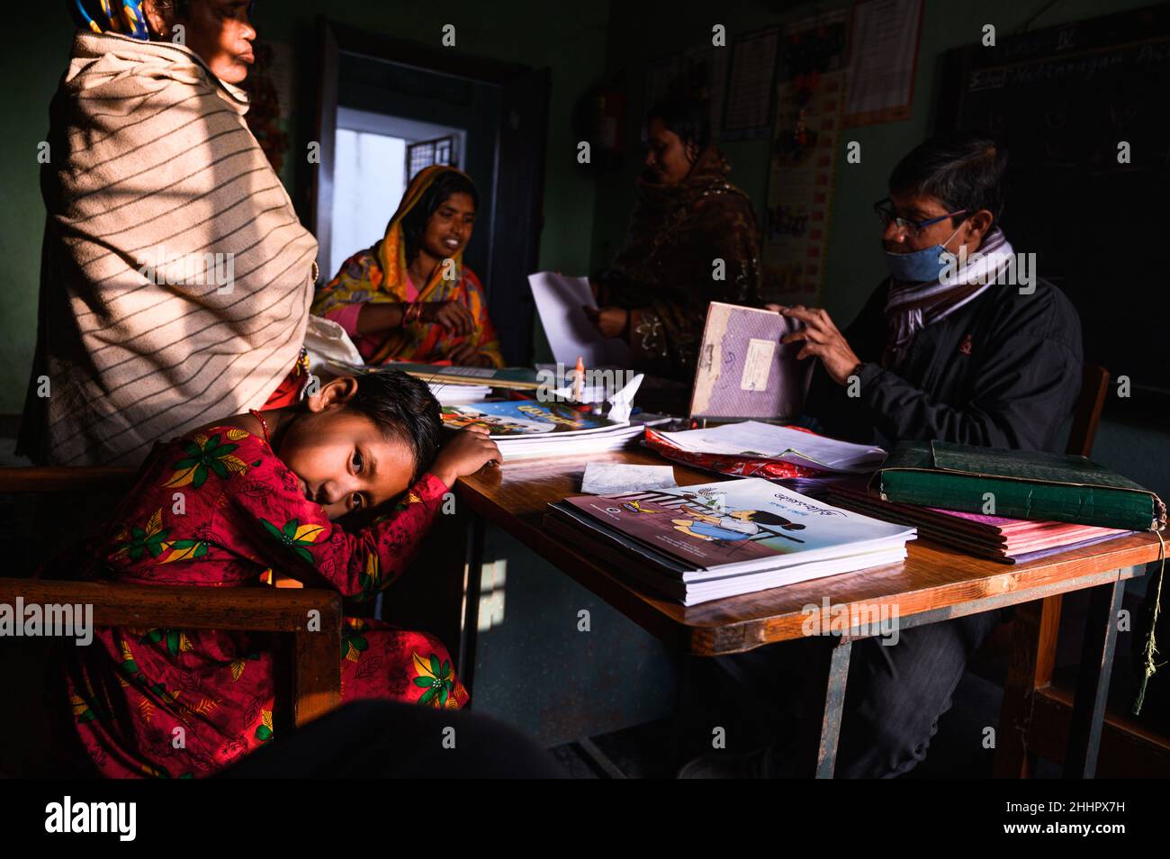 Gli studenti sono ammessi ad una scuola elementare rurale e i nuovi libri scolastici sono distribuiti liberamente agli studenti che sono forniti dal governo. Nabin Nagar, India. Foto Stock