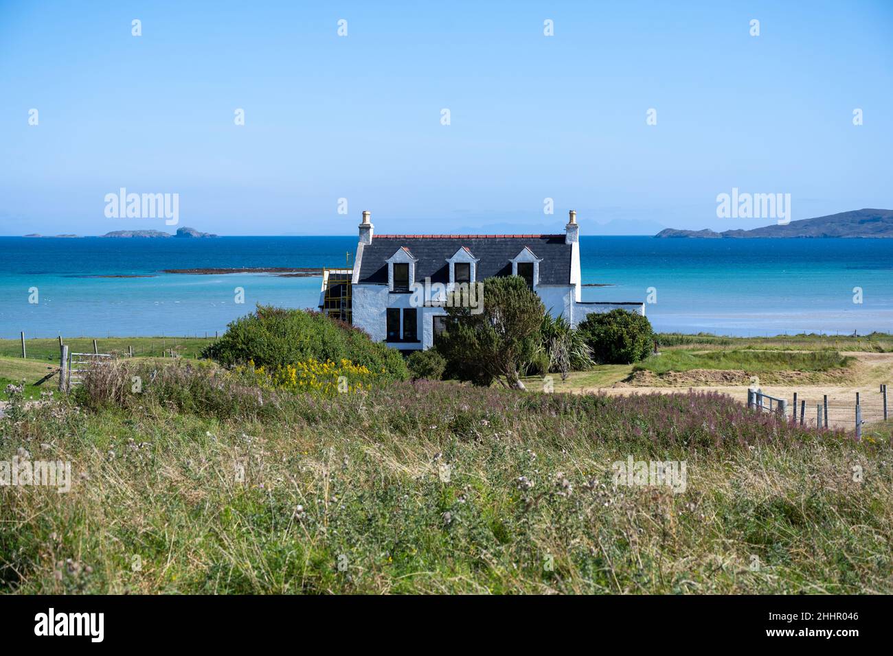 Un cottage residenziale con la piccola isola marea disabitata di Orosay sullo sfondo (a destra), Sound of barra, Eoligarry Foto Stock