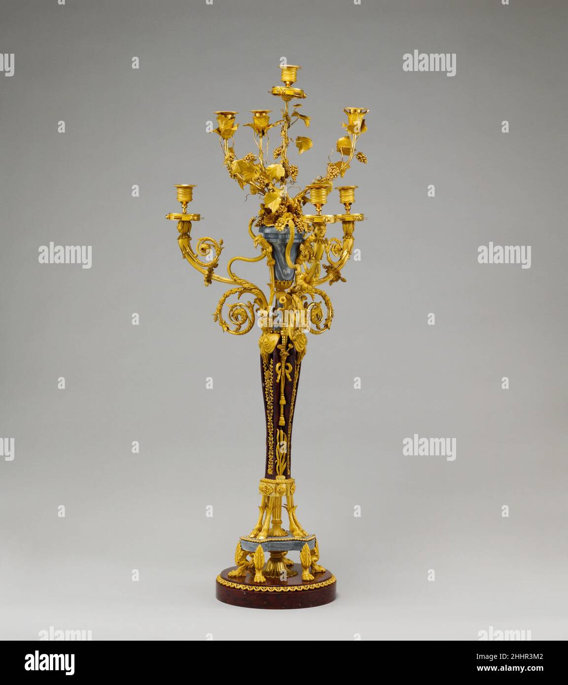 Coppia di candelabri a sette luci (candele o giranandole) ca. 1790 la Candelabra francese divenne sempre più elaborata nel corso del XVIII secolo e fu spesso colata di bronzo dorato. Monumentale per dimensioni, questo paio ha voluto contenere sette candele è molto complesso nel suo design. Disposto su due piani di tre rami e con un braccio aggiuntivo in alto, il modello incorpora due serie di piedi animali come supporto, zampe di leone e zoccoli di capra. Il gambo è sormontato da figure di termine femminili, possibilmente maenadi e i rami di scorrimento sul livello inferiore ciascuno terminano in un jester Foto Stock