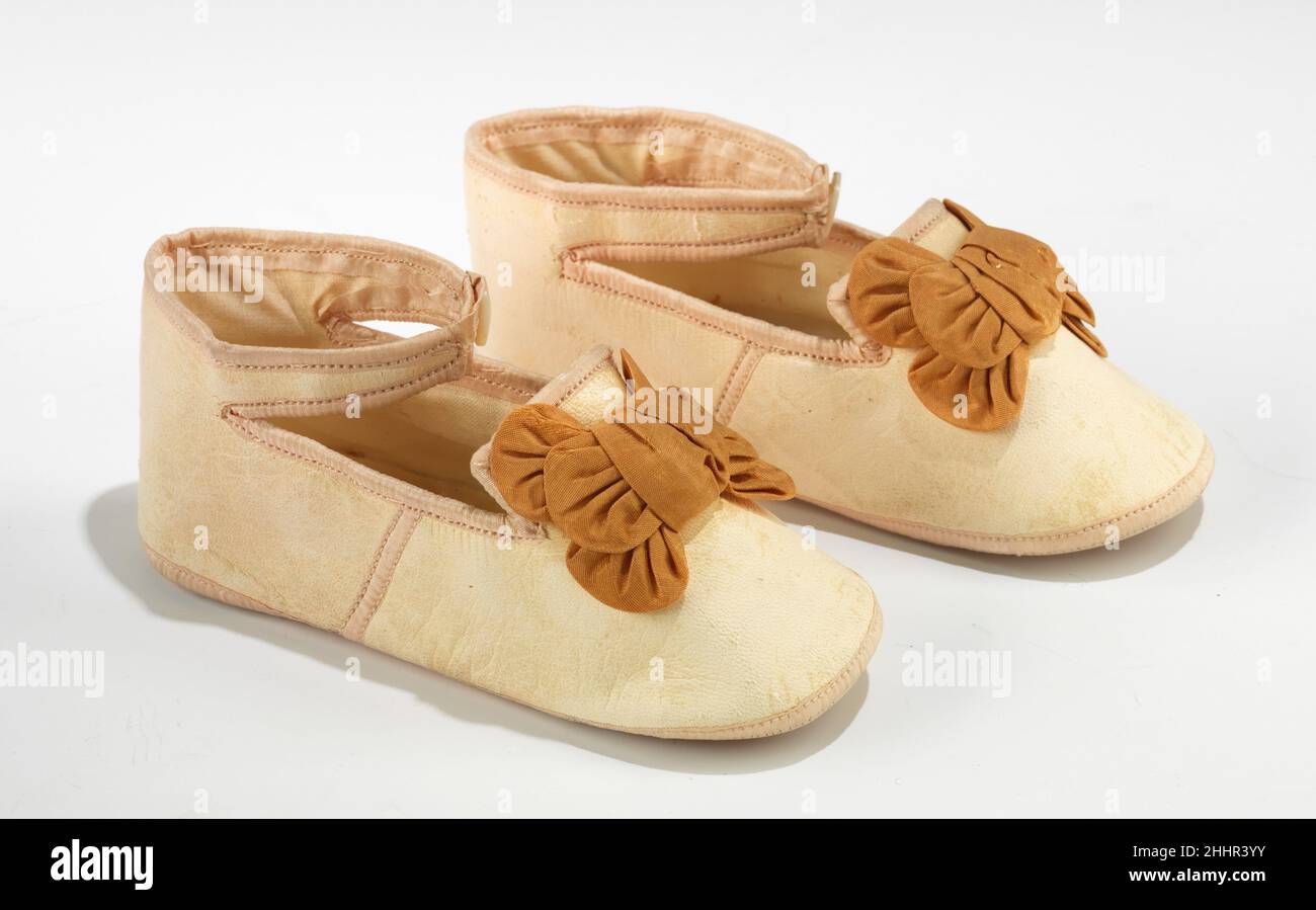Scarpe 1875–95 probabilmente francesi queste scarpe per bambini di alta qualità prendono in prestito uno stile di prua da scarpe donna alla moda del periodo. Gli stili dei bambini mostrano frequentemente gli elementi derivati dalla moda dell'adulto e questa varietà di arco a più livelli con 'orecchie' soffiato è stata vista frequentemente sulle scarpe da sera delle Signore del 1880s. Anche se hanno scolorito col tempo, le scarpe erano originariamente un rosa brillante. Scarpe 157877 Foto Stock