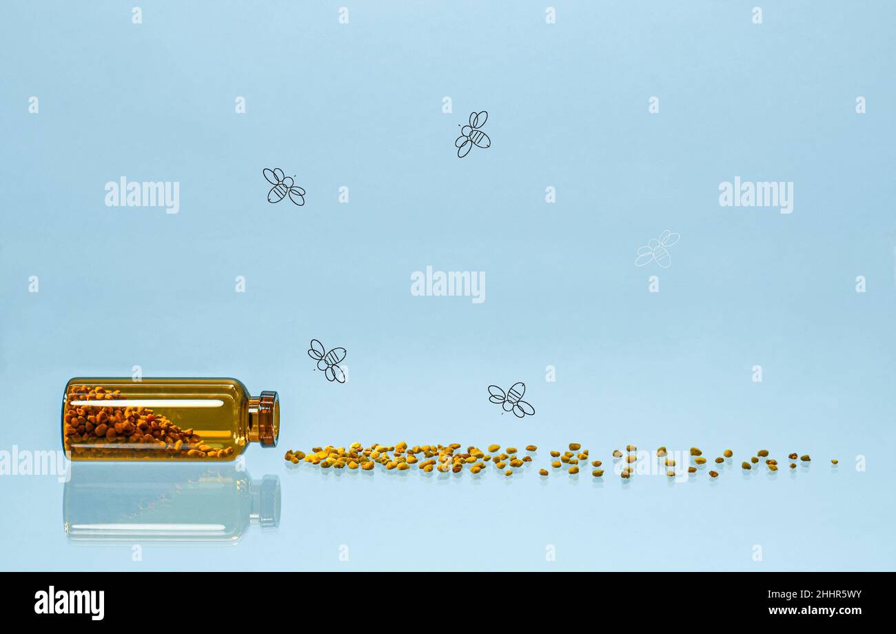 Una bottiglia di polline sparso e api che volano sopra di esso. Foto Stock