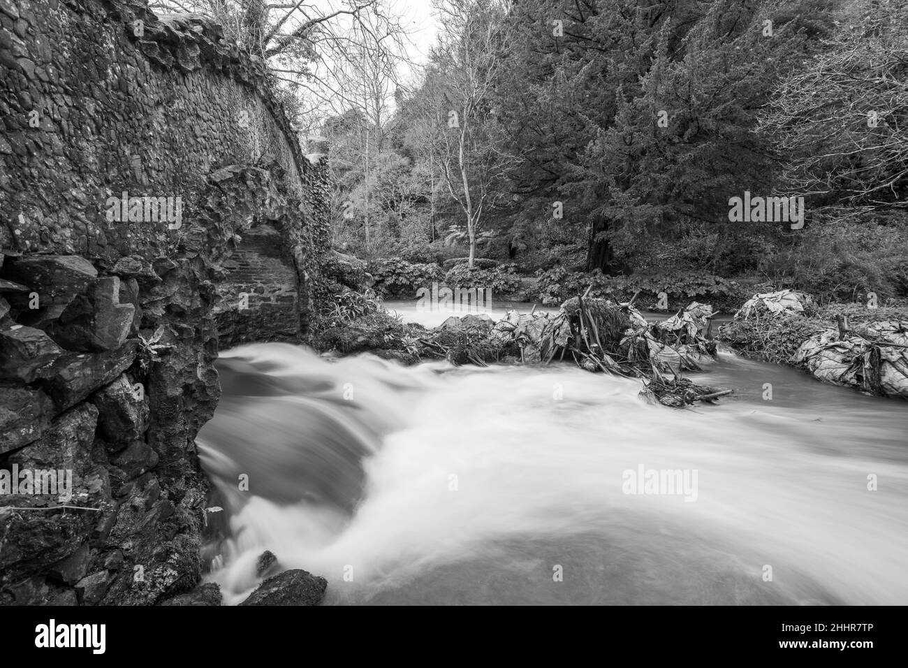 Lunga esposizione del fiume Avill che scorre sotto il ponte degli amanti nei terreni del castello di Dunster nel Somerset Foto Stock