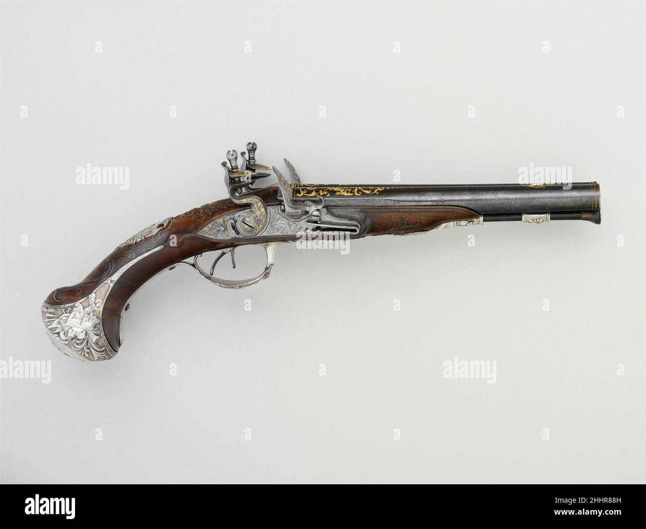 Coppia di pistole Flintlock a doppio tralicello 1752–53 le pistole francesi con barili affiancati di Francis-Alexander Chasteau divennero popolari in Inghilterra e in Francia nella seconda metà del XVIII secolo. Questa coppia francese lussuosamente decorata mostra l'elegante gusto rococò per asimmetria e finta nei suoi elaborati supporti in argento dorato e intarsio in filo d'argento. Coppia di pistole Flintlock a doppio tralicello 26587 Foto Stock