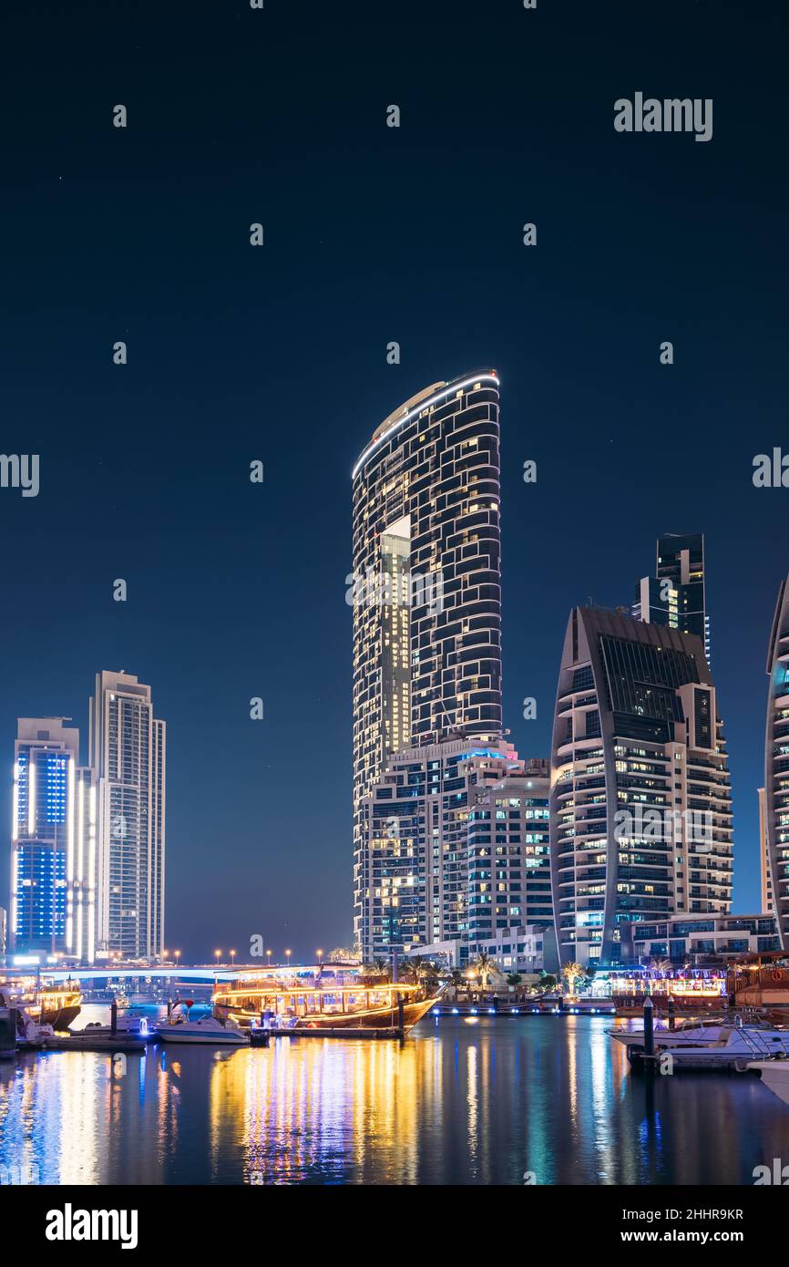 Vista notturna delle Dubai Marina Towers. Barche ormeggiate vicino al Molo della Città, Jetty nelle luci notturne Foto Stock