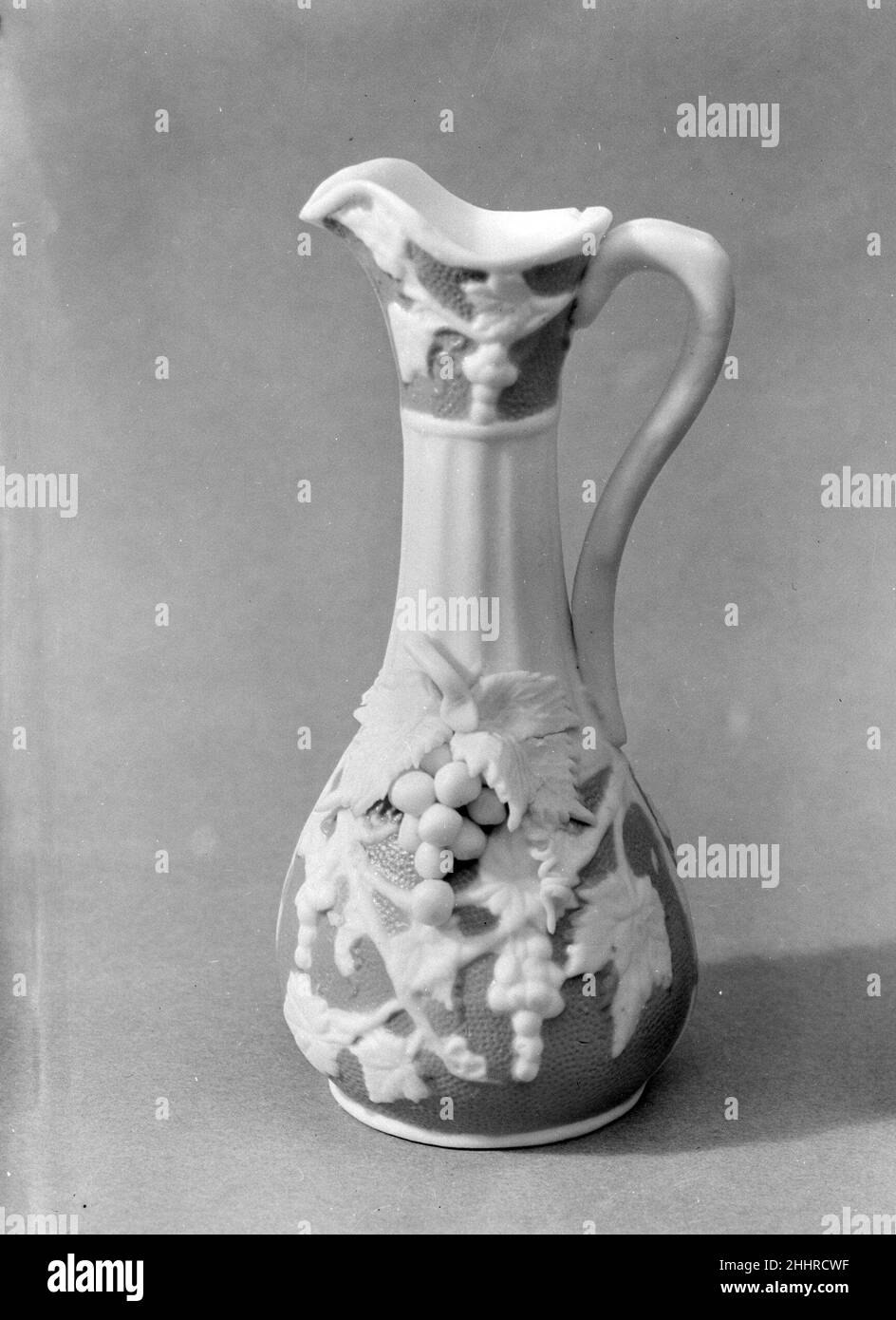 Ewer 1830–70 americano chiamato in riferimento all'antica cava di marmo sull'isola greca di Parros, parian ha una proporzione maggiore di feldspare rispetto alla porcellana convenzionale, dando luogo ad un corpo di biscotto vetrificato che assomiglia al marmo bianco di statuaria. Elegante e accessibile, statue e oggetti da toletta di parian erano ornamenti di famiglia estremamente popolari nella metà del diciannovesimo secolo. Questo cucito è stato probabilmente fatto dalla United States Pottery Company, che ha esposto parian a grande acclamazione alla New York Crystal Palace Exhibition 1853 a New York. Ewer. Americano. 1830–70. Porcellana di Parian. Probabilmente fatto Foto Stock