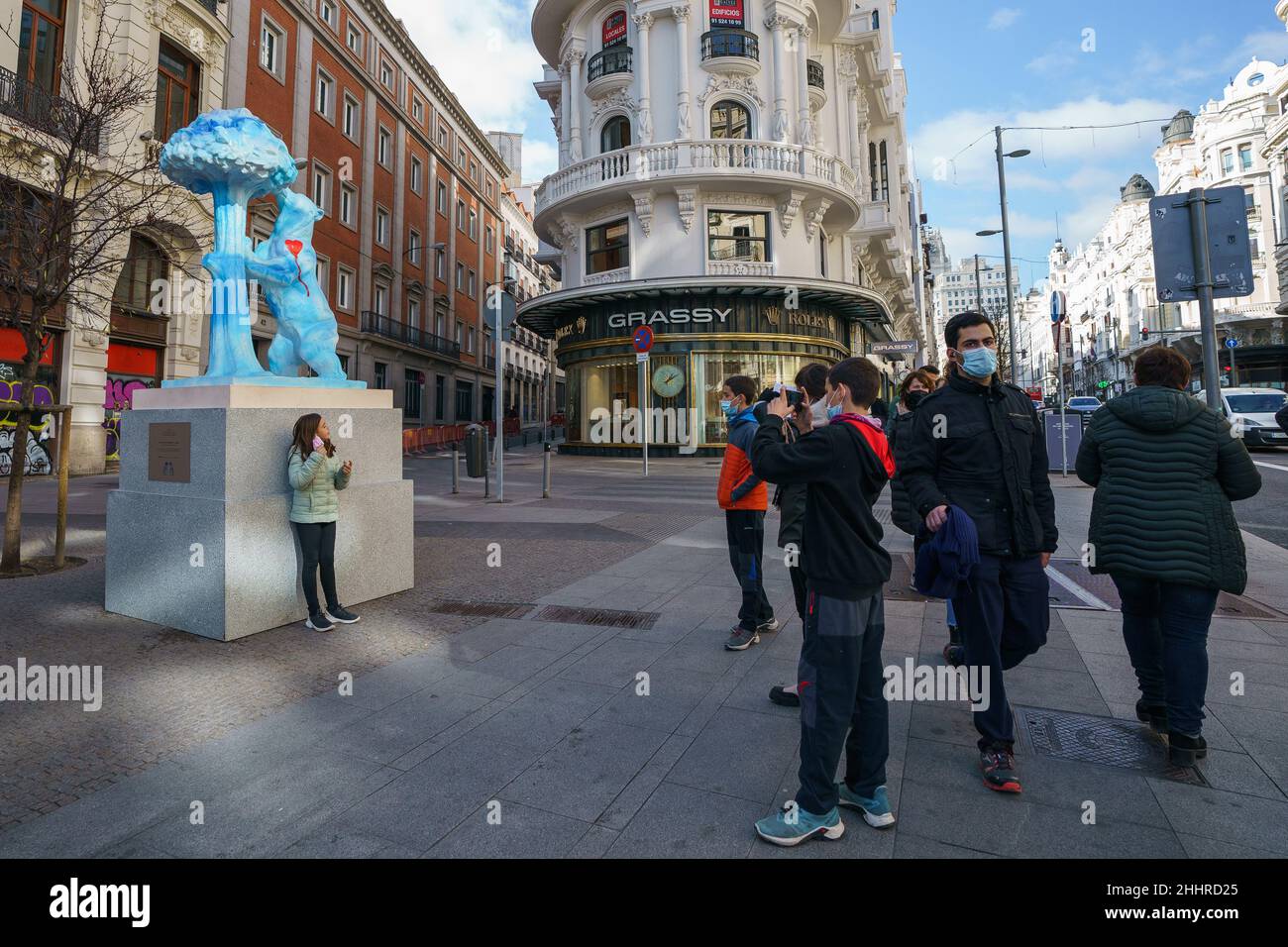 Una giovane ragazza ottiene la sua foto scattata di fronte alla replica della statua dell'Orso e dell'albero della fragola (El Oso y el Madroño) sotto il titolo 'il cielo di Madrid vi ama' e dipinta dall'artista i fratelli Vicente e Paloma Delgado, È visto durante la mostra, 'grazie molto, Madrid!' Come omaggio a coloro che hanno partecipato alla lotta contro la pandemia di Covid-19 a Madrid. L'iniziativa di esposizione urbana presentata in 21 distretti di Madrid è stata organizzata dal gruppo Prisa e rimarrà per le strade di Madrid fino a febbraio 18. Foto Stock