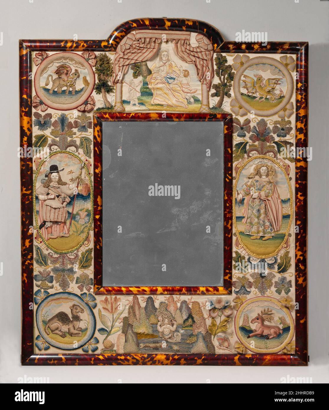 Specchio con Jael e Barak 1672 britannico la decorazione ricamata di questa cornice a specchio è stata derivata da una fonte stampata come una Bibbia illustrata e presenta una composizione simile a quella di una pagina di titolo decorativa. I personaggi biblici Jael e Barak, affiancati al vetro dello specchio, appaiono nel libro dei Giudici. La cornice è sormontata da una figura di Carità; gli animali, mitici e reali, che simboleggiano i quattro continenti, occupano gli angoli (dall'alto a sinistra): Un griffin che rappresenta l'Africa, un basilisk che rappresenta l'America, un celibe che rappresenta l'Europa, e un cammello per l'Asia. Specchio con Jael An Foto Stock Specchio con Jael e Barak 1672 britannico la decorazione ricamata di questa cornice a specchio è stata derivata da una fonte stampata come una Bibbia illustrata e presenta una composizione simile a quella di una pagina di titolo decorativa. I personaggi biblici Jael e Barak, affiancati al vetro dello specchio, appaiono nel libro dei Giudici. La cornice è sormontata da una figura di Carità; gli animali, mitici e reali, che simboleggiano i quattro continenti, occupano gli angoli (dall'alto a sinistra): Un griffin che rappresenta l'Africa, un basilisk che rappresenta l'America, un celibe che rappresenta l'Europa, e un cammello per l'Asia. Specchio con Jael An Foto Stock