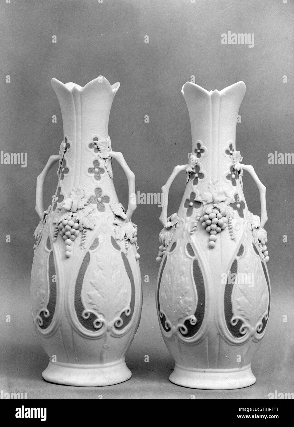 Vaso 1830–70 americano chiamato in riferimento all'antica cava di marmo sull'isola greca di Parros, parian ha una proporzione più alta di feldspare rispetto alla porcellana convenzionale, dando luogo ad un corpo di biscotto vetrificato che assomiglia al marmo bianco della statuaria. Elegante e accessibile, statue e oggetti da toletta di parian erano ornamenti di famiglia estremamente popolari nella metà del diciannovesimo secolo. Questa nave e il suo compagno (47.90.24) è stato probabilmente fatto dalla United States Pottery Company, che espone parian a grande acclamazione alla Crystal Palace Exhibition del 1853 a New York. Vaso. Americano. 1830–70. Porcellana di Parian. Foto Stock