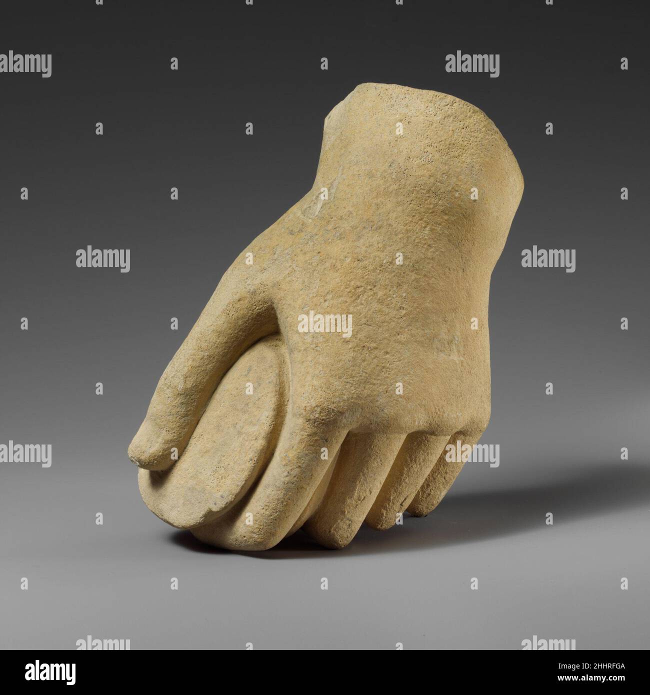Mano di calcare che tiene un pyxis Cypriot la mano sinistra di sovra-vita tiene un pyxis. La punta delle dita è indicata da una linea in rilievo. Mano di calcare che tiene un pyxis 242282 Foto Stock