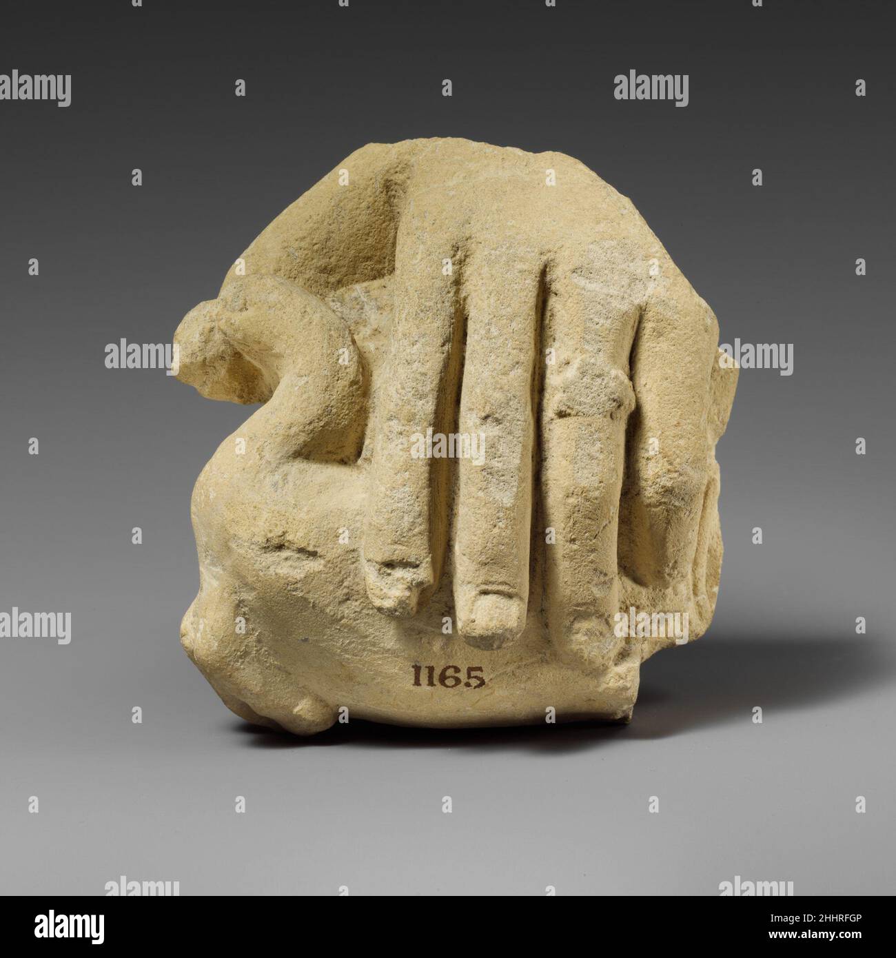 Mano calcarea che tiene un uccello 3rd–1st secolo a.C. Cipriota la mano sinistra salvavita, le cui dita sono molto sottili, tiene una piccola anatra. È presente un anello sulla ghiera. Mano di calcare che tiene un uccello 242272 Foto Stock