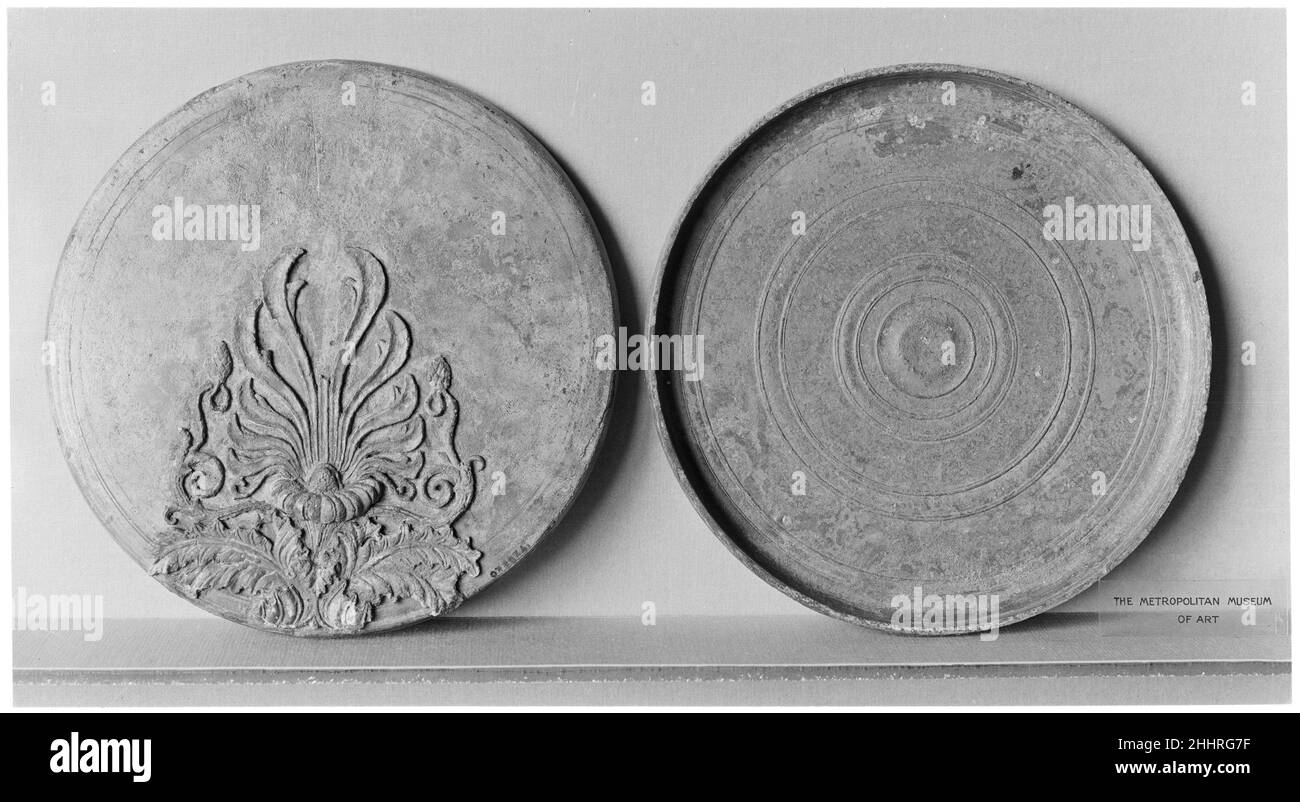 Scatola di bronzo specchio 2nd quarto del 4th secolo a.C. greco in rilievo, Ornamento floreale gli elementi geometrici e floreali hanno svolto un ruolo importante nella decorazione di tutti i tipi di arte greca. Qui le lussureggianti foglie di acanthus danno origine a tendri curling esterni con frutta e ad un elemento centrale fiorito da cui scaturisce una palmette con fronti ingirati. Specchio in bronzo. Greco. 2nd quarto del 4th secolo a.C. Bronzo. Tardo classico. Bronzi Foto Stock