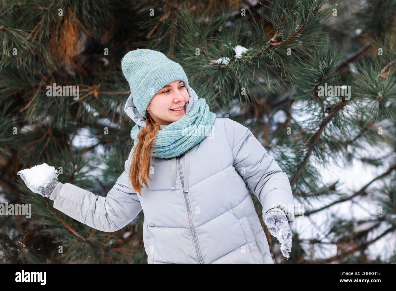 Ragazza felice adolescente divertirsi giocando con le palle di neve, pronto a lanciare la palla di neve. Giochi di neve. Vacanze invernali. Foto Stock