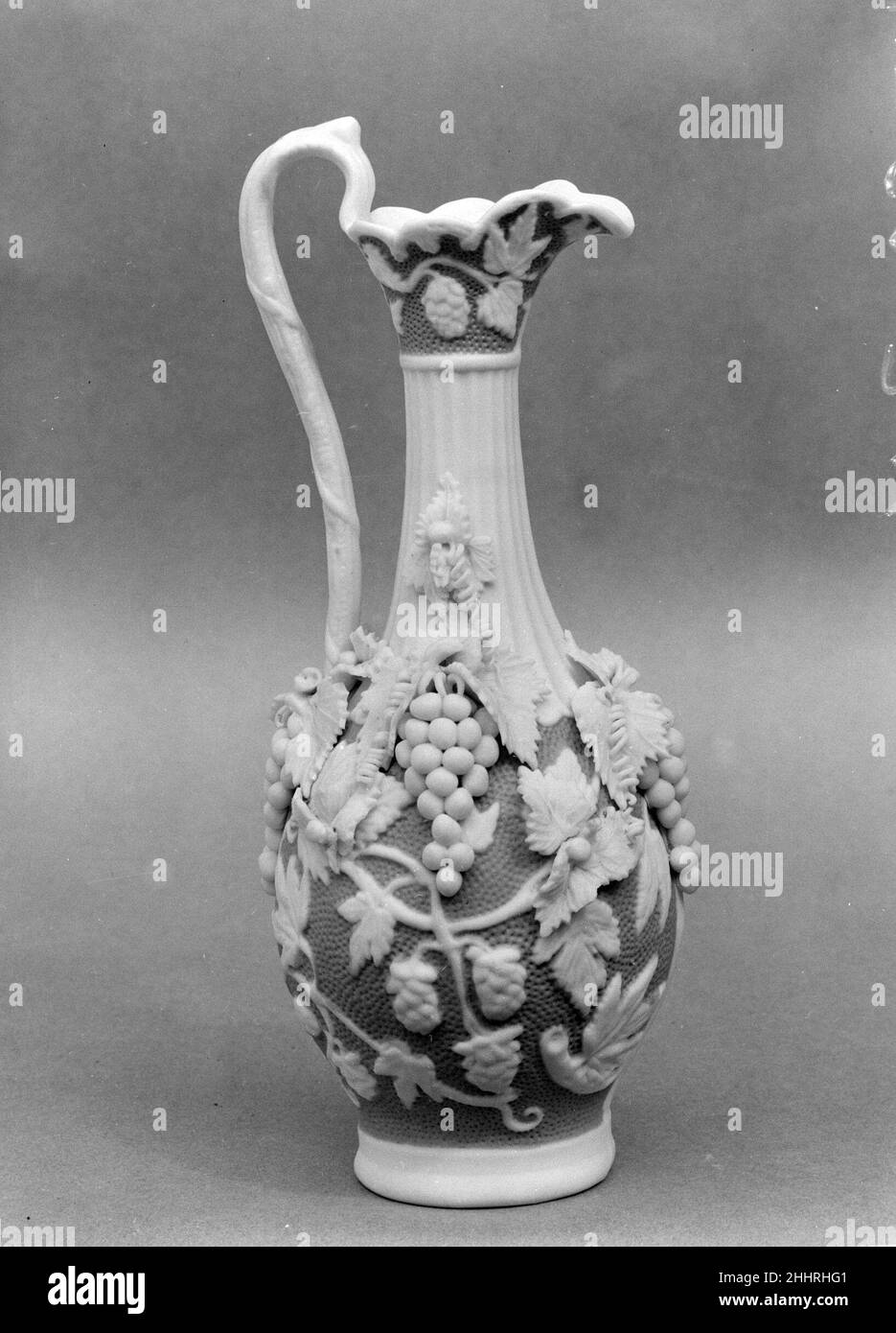 Ewer 1830–70 americano chiamato in riferimento all'antica cava di marmo sull'isola greca di Parros, parian ha una proporzione più alta di feldspare rispetto alla porcellana convenzionale, dando luogo ad un corpo di biscotto vetrificato che assomiglia al marmo bianco della statuaria. Elegante e accessibile, statue e oggetti da toletta di parian erano ornamenti di famiglia estremamente popolari nella metà del diciannovesimo secolo. Questo vascello è stato probabilmente fatto dalla United States Pottery Company, che ha esposto parian a grande acclamazione alla mostra di Crystal Palace 1853 a New York. Ewer. Americano. 1830–70. Porcellana di Parian. Probabilmente fabbricato a Bennin Foto Stock