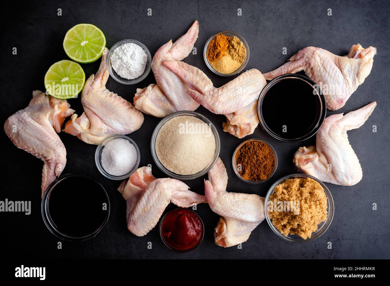 Cinese cinque ali di pollo alle spezie con soia, riduzione balsamica glassa ingredienti: Vista dall'alto delle ali di pollo crude con ingredienti per fare la marinata Foto Stock