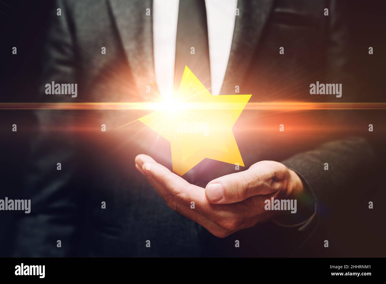 Uomo d'affari che detiene luccicante stella premio in mano, cliente di revisione concetto, fuoco selettivo Foto Stock