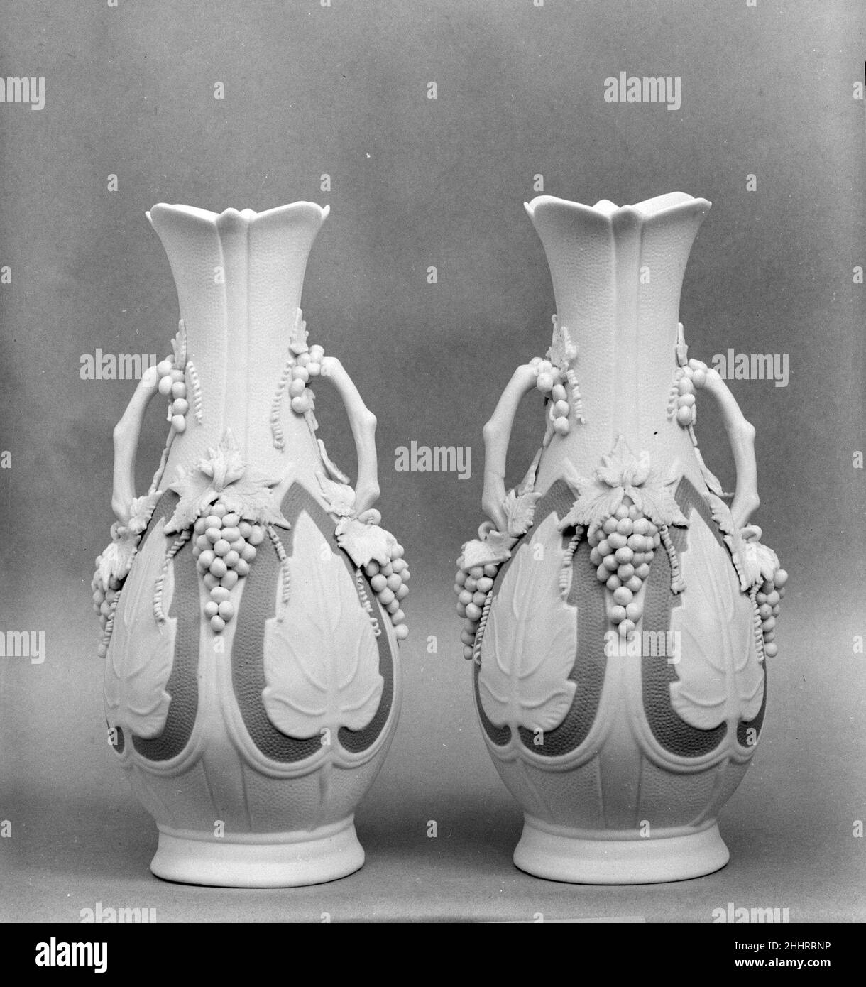 Vaso 1830–70 americano chiamato in riferimento all'antica cava di marmo sull'isola greca di Parros, parian ha una proporzione più alta di feldspare rispetto alla porcellana convenzionale, dando luogo ad un corpo di biscotto vetrificato che assomiglia al marmo bianco della statuaria. Elegante e accessibile, statue e oggetti da toletta di parian erano ornamenti di famiglia estremamente popolari nella metà del diciannovesimo secolo. Questa nave e il suo compagno (47.90.64) è stato probabilmente fatto dalla United States Pottery Company, che espone parian a grande acclamazione alla Crystal Palace Exhibition del 1853 a New York. Vaso. Americano. 1830–70. Porcellana di Parian. Foto Stock