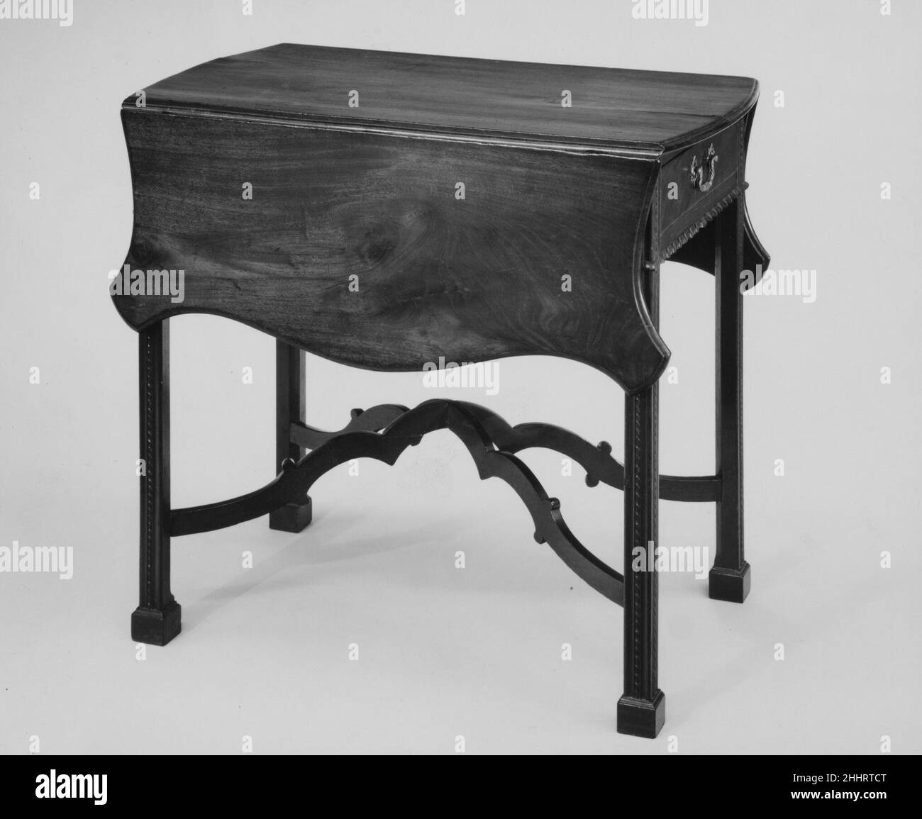 Pembroke Table 1765–90 americano questo è un ottimo esempio, con tutti gli extra, del Philadelphia Pembroke, o prima colazione, tabella. Nel listino prezzi 1772 di un cabinettista di Philadelphia, un mogano “piano per la colazione” costava “2-15-0” (2 libbre, 15 scellini, senza recinzione); con un cassetto, “Brasses & Brackets” e “un barella semplice”, il prezzo era “3-10-0”. “aggiungere per scalloping la Top 4s[hillings]” e il risultato sarebbe questa tabella, costando 3 libbre, 14 shillings. Tavolo Pembroke. Americano. 1765–90. Mogano, quercia, pino bianco, pioppo tulipano. Fabbricato a Philadelphia, Pennsylvania, Stati Uniti Foto Stock