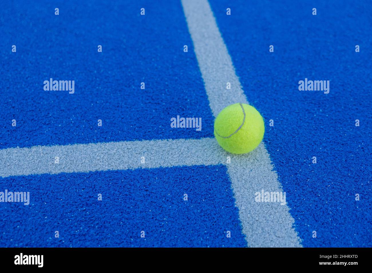 Una palla sulla linea di un campo da paddle tennis di erba sintetica blu. Concetto di salute e sport Foto Stock