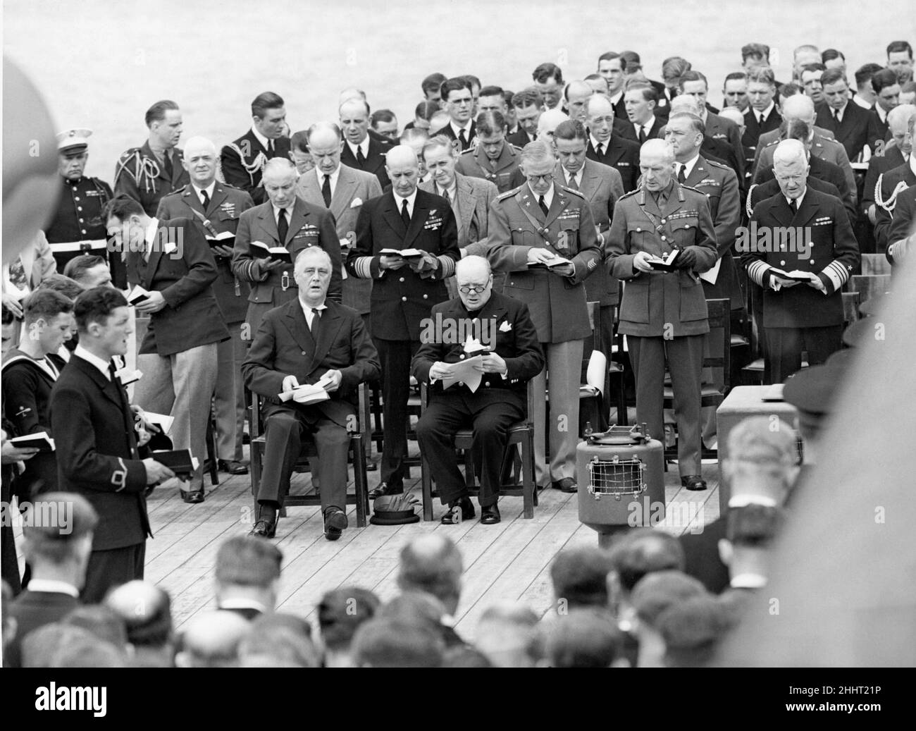Il presidente Franklin Roosevelt e il primo ministro Winston Churchill cantano inni durante il servizio Divino a bordo della HMS Prince of Wales. Agosto 1941 Foto Stock