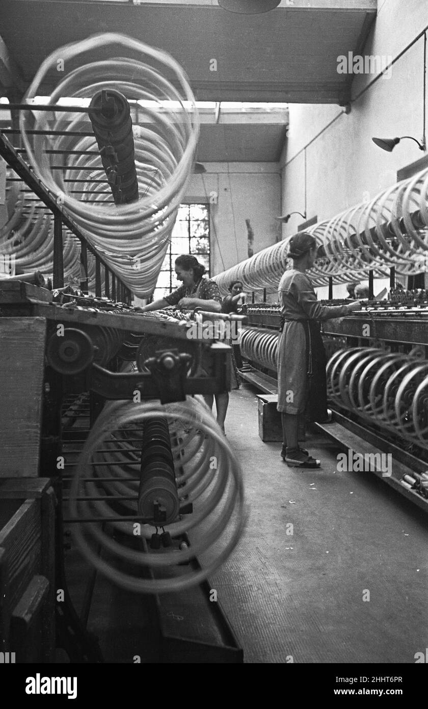 Le donne lavoratrici scherzano mentre sorvegliano la filatura del cotone, Miklan, Italia. Circa 1955 Foto Stock