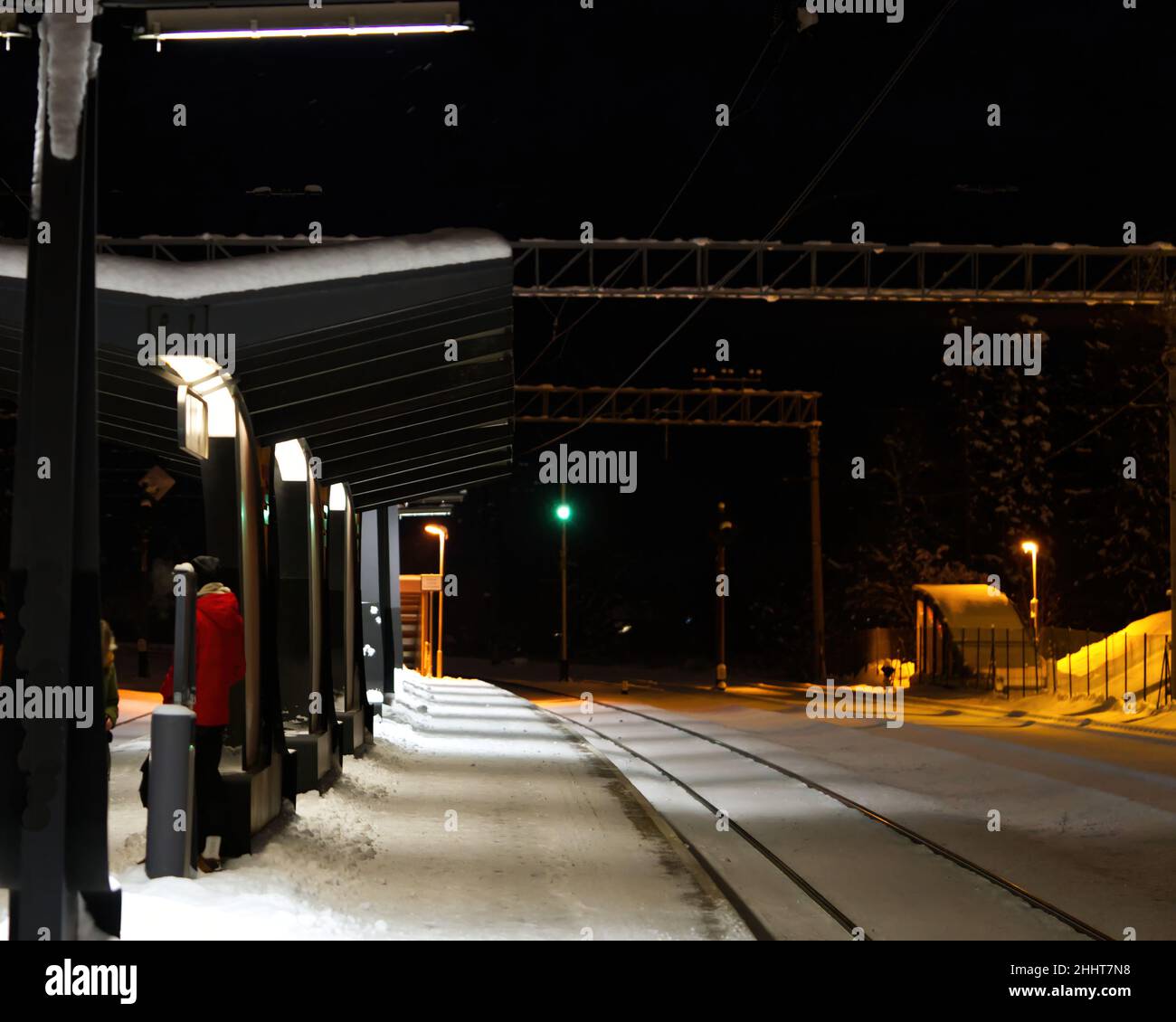 Piattaforma ferroviaria coperta di neve di notte. Estonia Lockal stazione ferroviaria. Foto Stock