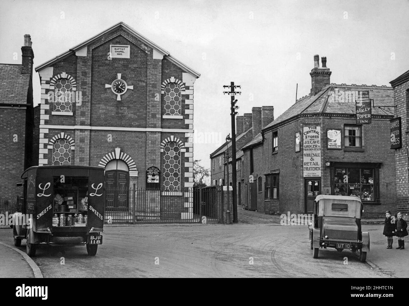 Consegna dolce ai negozi centrali nel centro di Barlestone, Leicestershire, come due giovani ragazzi desiderosi guardare. 2nd dicembre 1938 Foto Stock