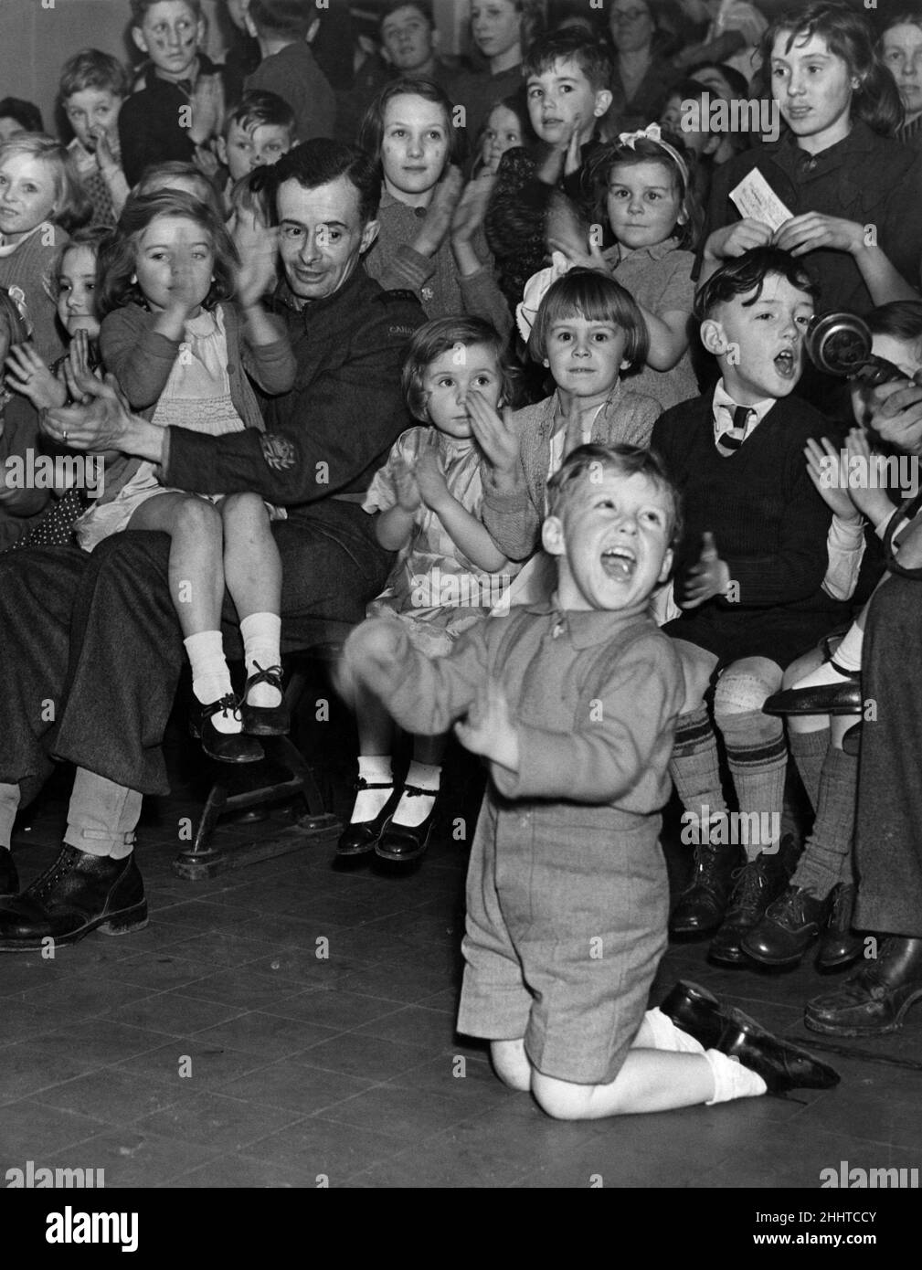 I bambini si godono un viaggio al cinema per guardare 'Pop Eye', come speciale regalo di Capodanno, anche un soldato canadese che è riuscito a parlare la sua strada in, il 31st dicembre 1943. Foto Stock
