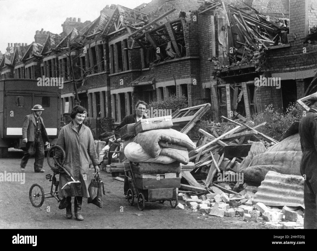 Coppia che porta i rimanenti possedimenti dalla loro casa bombardata in un pam a seguito di un attacco nemico a North West London durante la seconda guerra mondiale. 16th febbraio 1941. Foto Stock