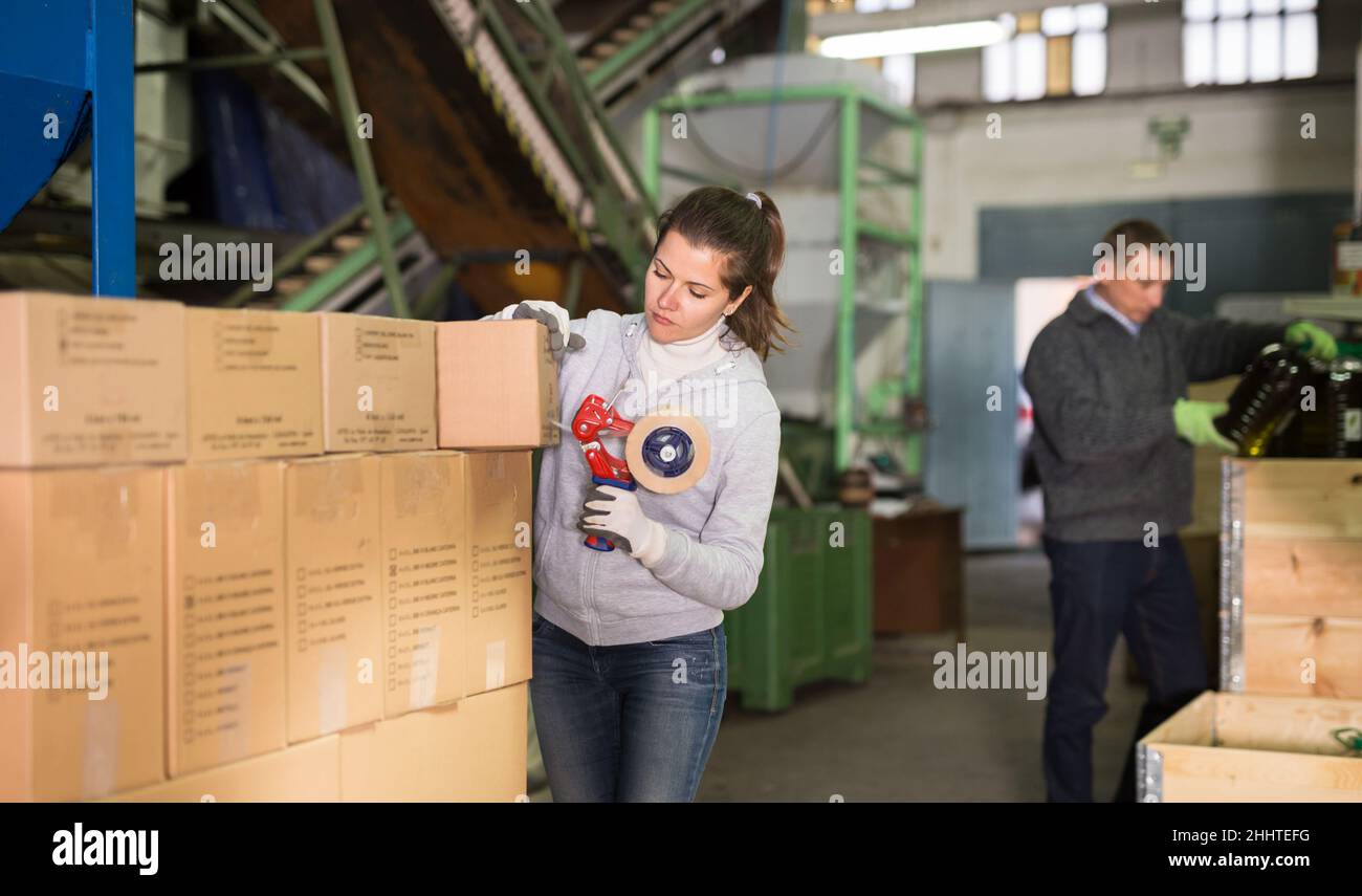 Scatole di cartone sigillanti femmina con nastro adesivo Foto Stock