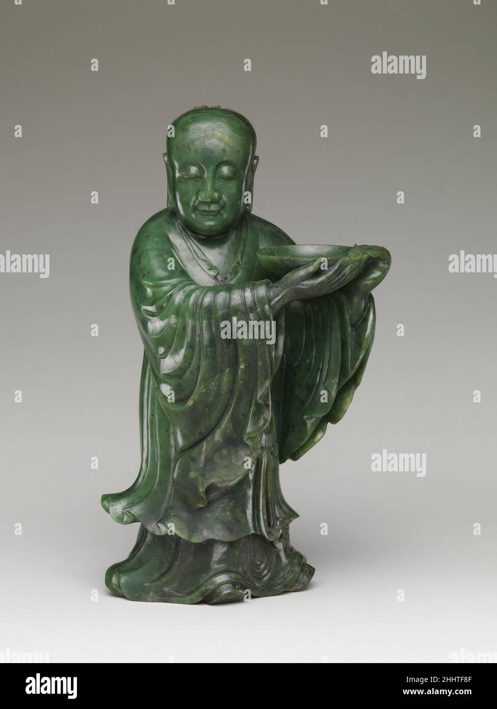 Cina immortale del 18th secolo questa coppia (con 2015.500.5.12) di figure scultoree è rappresentativa della scultura di giada dal laboratorio imperiale Qing. Le dimensioni sostanziali delle figure esemplificano l’uso imperiale di preziosi materiali di lusso. Disegnate come due ragazzi che reggono le piastre, le figure sono raffigurate con sorrisi sottili e misteriosi, un'indicazione che non provengono dal mondo mondano ma da una terra immortale. Anche la storia di come sono entrati nella collezione Met è straordinaria. La figura a sinistra è stata un regalo al Museo dal collezionista di giada e dal fiduciario del museo Foto Stock