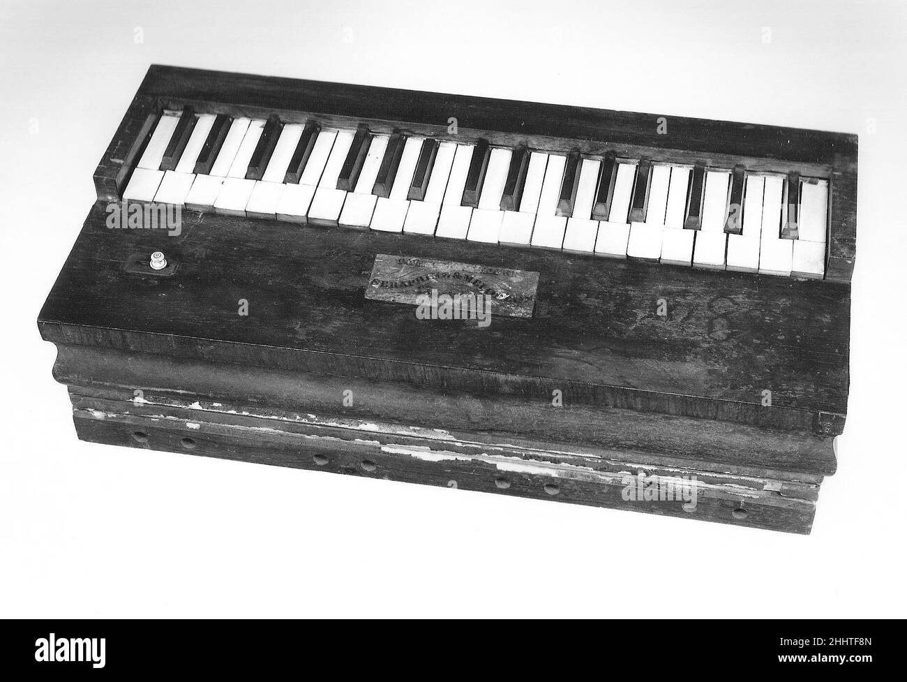 Melodeon a dondolo ca. 1843 Caleb Packard il melodeon o organo 'dondolo' ha ricevuto questo moniker perché doveva essere pompato su e giù (la tastiera quindi dondola) per pompare il soffietto per suonare le canne.Descrizione tecnica: Caso rettangolare di impiallacciatura di palissandro sopra un doppio soffietto diviso diagonalmente; Pannello superiore rimovibile con etichetta in carta sulla parte anteriore, tastiera lungo il bordo posteriore; bussola G-g2, avorio naturale, ebony accidentale; canne senza ottone sotto la parte anteriore del pannello frontale rimovibile, ogni canne con un numero romano incisa (i-VIII, ripetuto); canne soffiate piuttosto Th Foto Stock