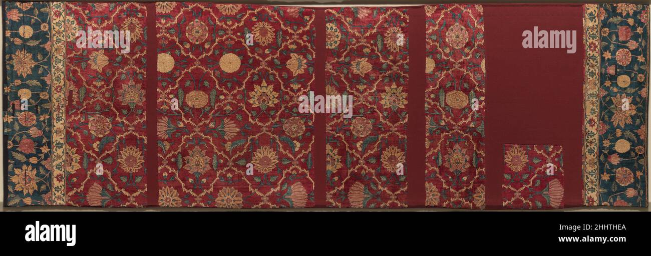 Frammenti di un tappeto modello Trellis ca. 1650 la lunghezza originale di questo tappeto era di trenta piedi impressionanti, indicando il relativo uso in un edificio reale per ospitare il pubblico o altre occasioni speciali. Sulle pareti e sui soffitti di tali edifici sono stati dipinti anche tralicci simili che racchiudono fioriture, e fregi floreali coprivano i dados e le facciate, creando un mondo di sontuosi fiori che circondano l'imperatore. Il Kashmir, con la sua tradizione di tessitura della pashmina, è probabilmente la fonte di tappeti di pashmina come questo, ma le officine di Lahore hanno prodotto anche molti tappeti di tipo imperiale a metà Foto Stock