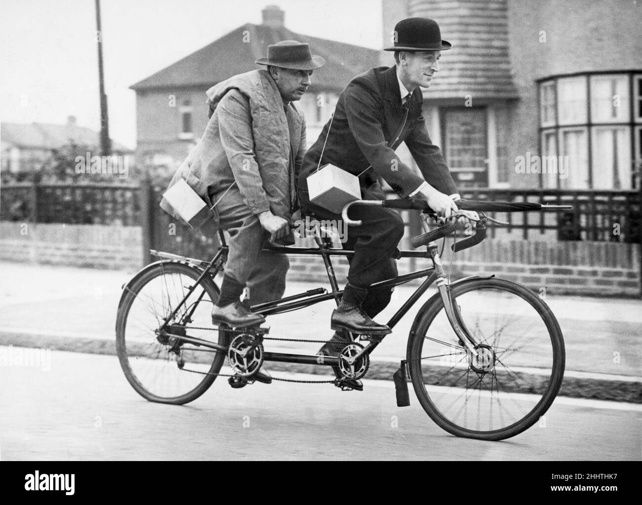 Due uomini d'affari che di solito viaggiano in città in auto condividono un ciclo tandem dopo l'introduzione del razionamento a benzina il 22nd settembre 1939 Foto Stock